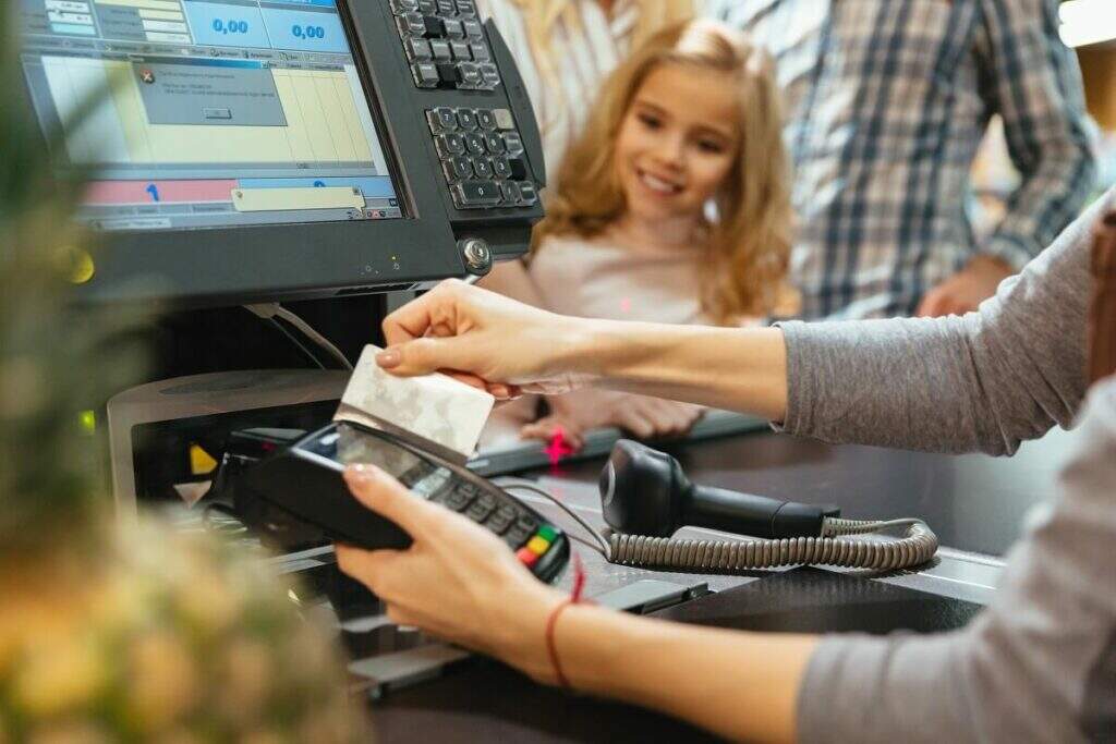 Família pagando suas contas no supermercado