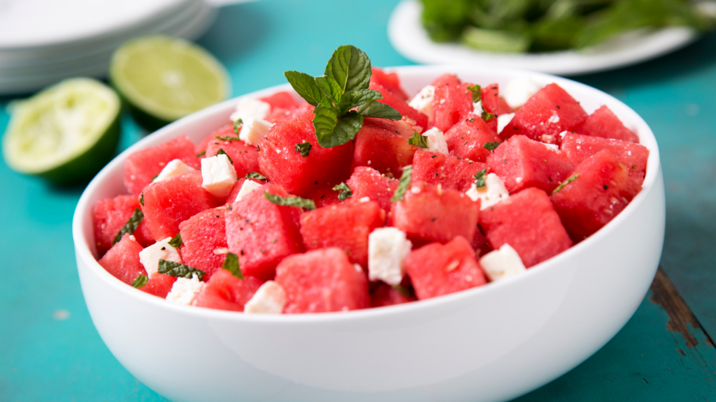 Melancia e queijo fresco cortados em pequenos cubos em um bowl branco, receitas com frutas