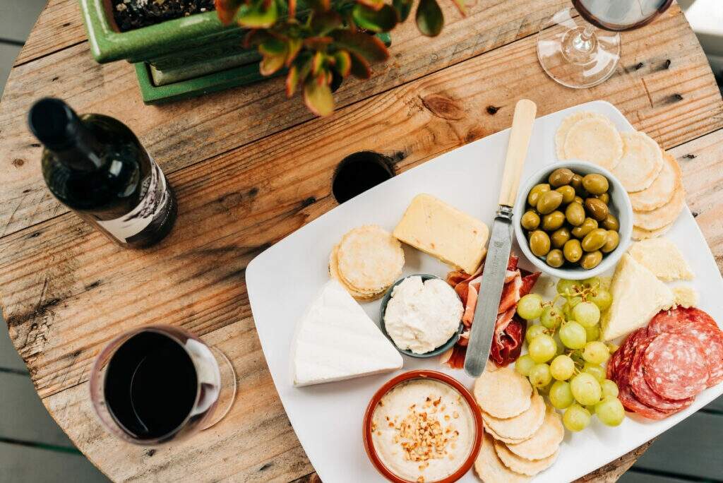 Mesa com queijo, vinho e frios