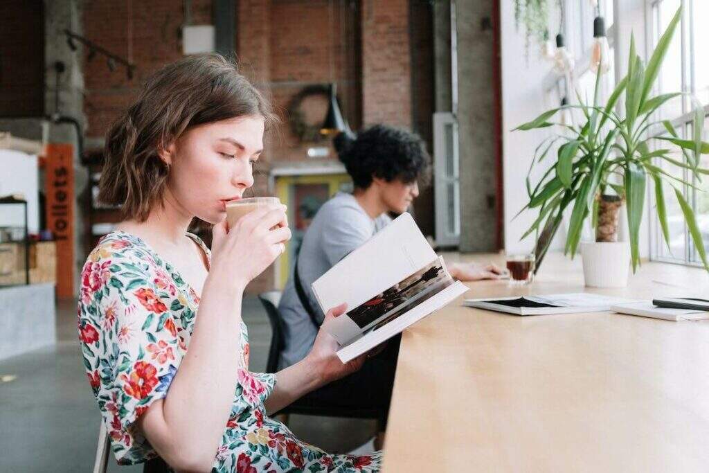 Mulher Com Camisa Floral Vermelha E Azul Branca Segurando Um Livro Branco