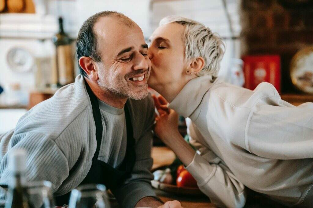 Casal cozinhando e sorrindo