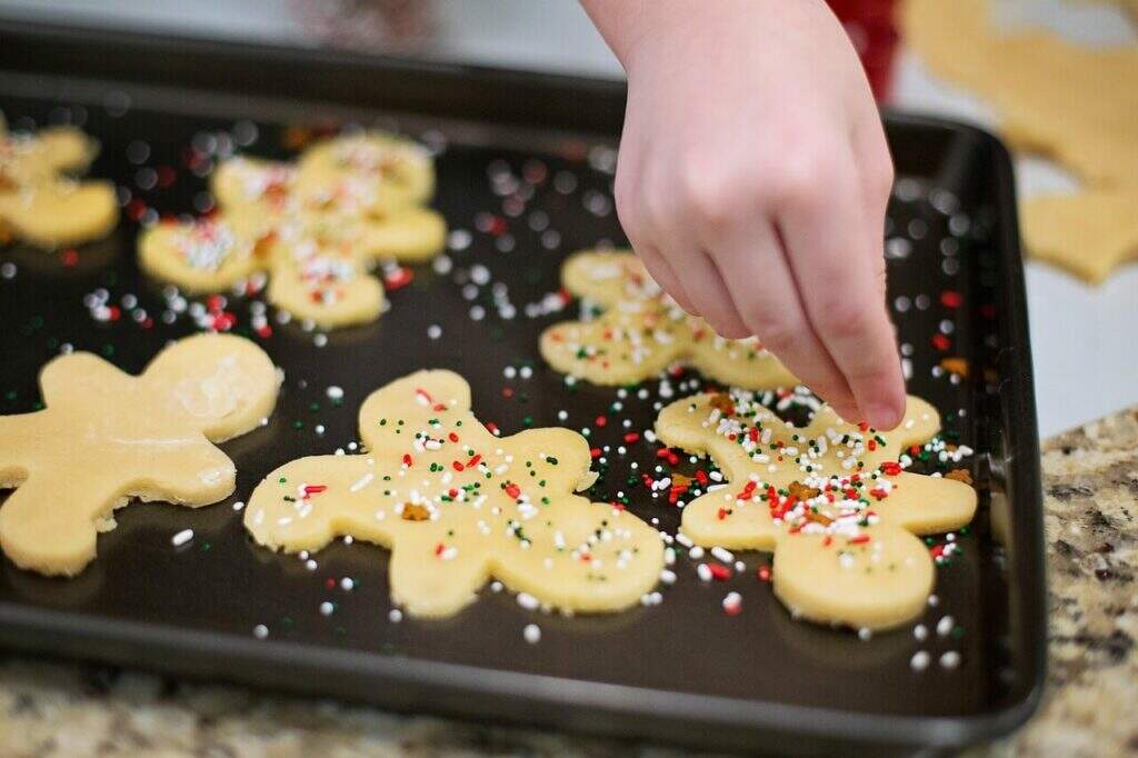 Criança confeitando biscoito em formato de boneco