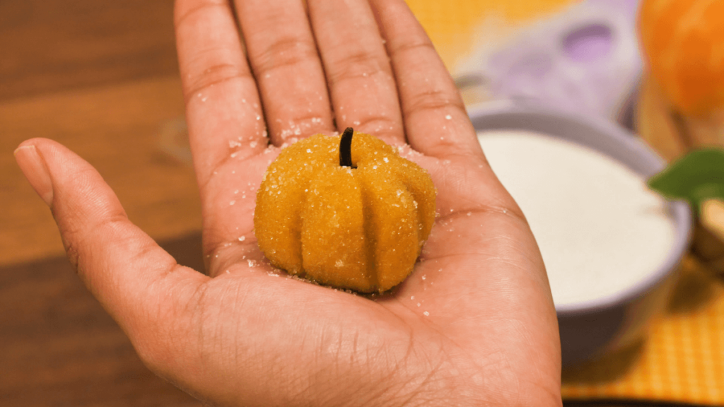 mão segurando um brigadeiro de abóbora 