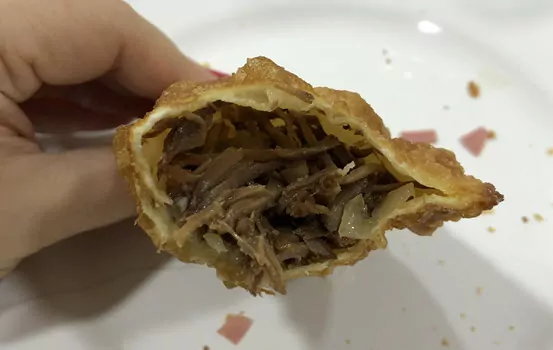 pastel com recheio de carne desfiada acebolada